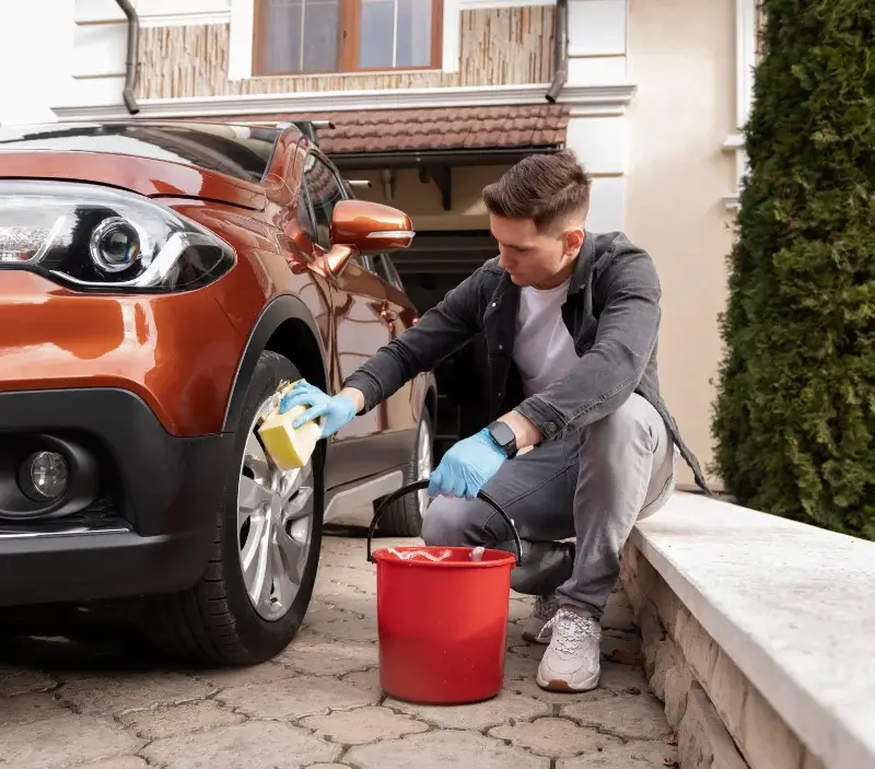 Lavage auto à domicile Uzos : professionnel intervenant sur un véhicule